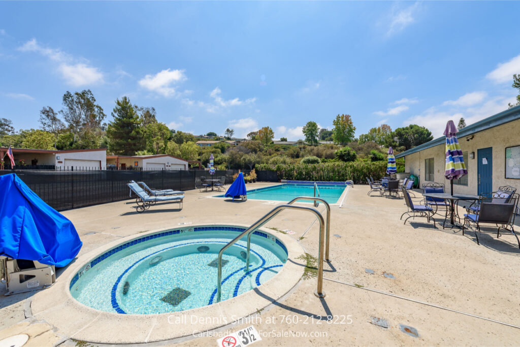 4414 Chickadee Way Oceanside Home for Sale including swimming pool, spa, lounge chairs, and shaded patio tables under a clear blue sky.