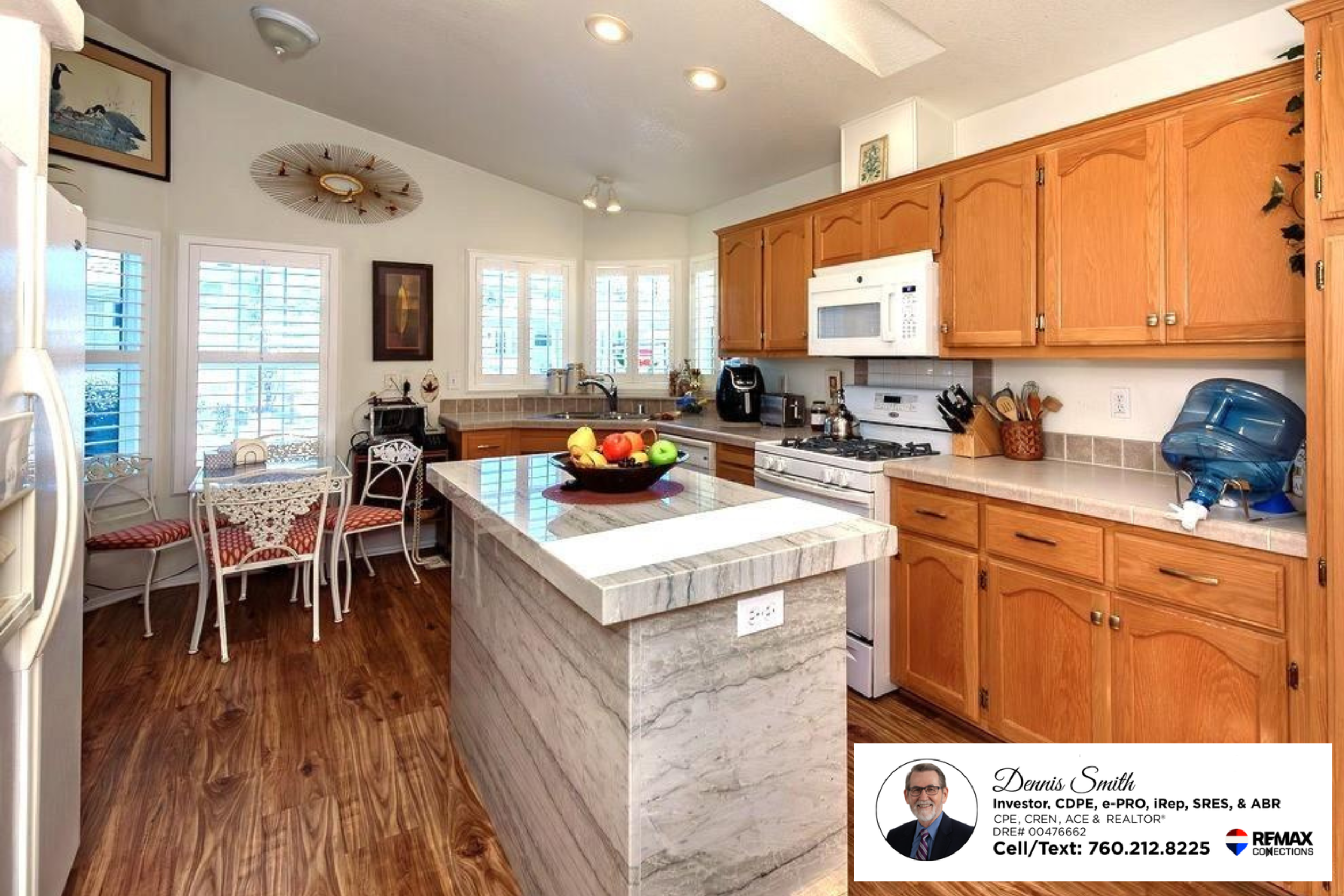Updated kitchen featuring wood cabinetry, recessed lighting, skylights, modern countertops, center island workspace, and bright natural light creating a functional and welcoming cooking space.